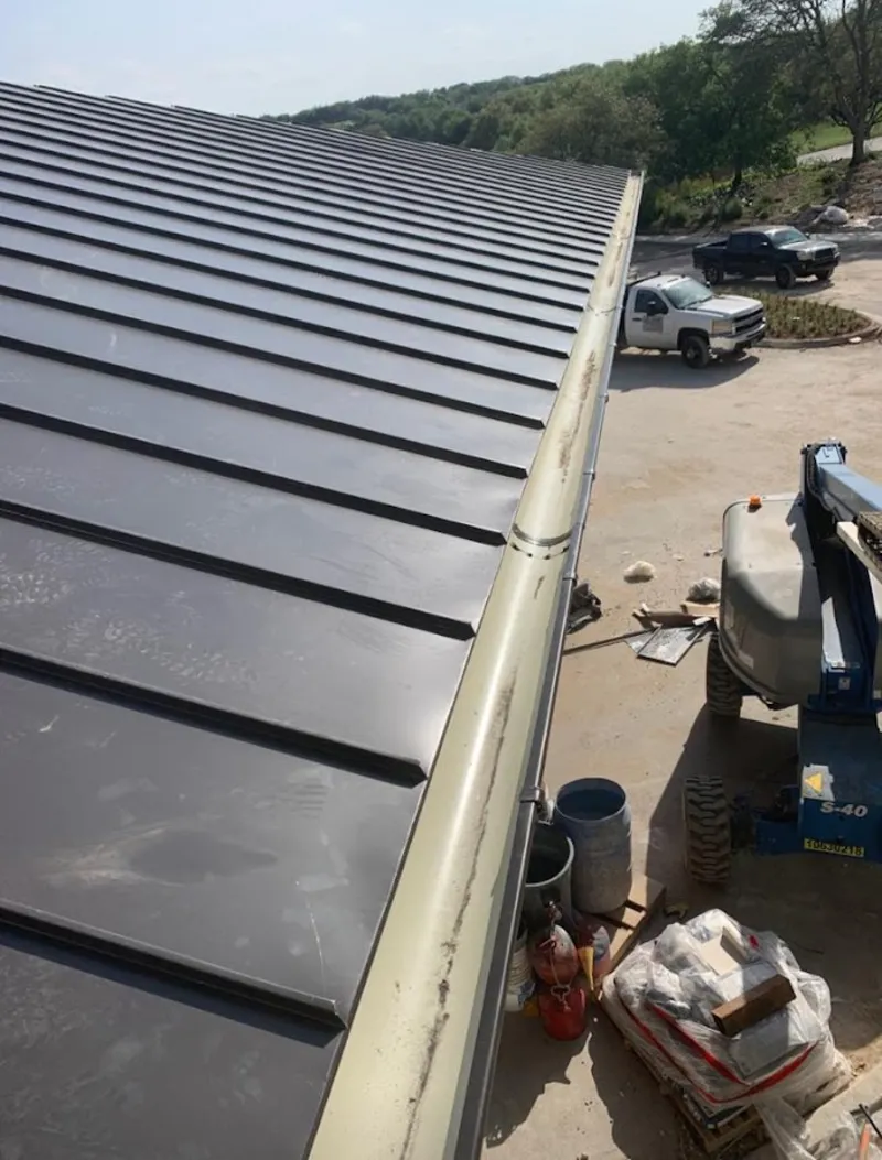 Standing seam panel and gutter detail on a metal roofing jobsite in Beardstown